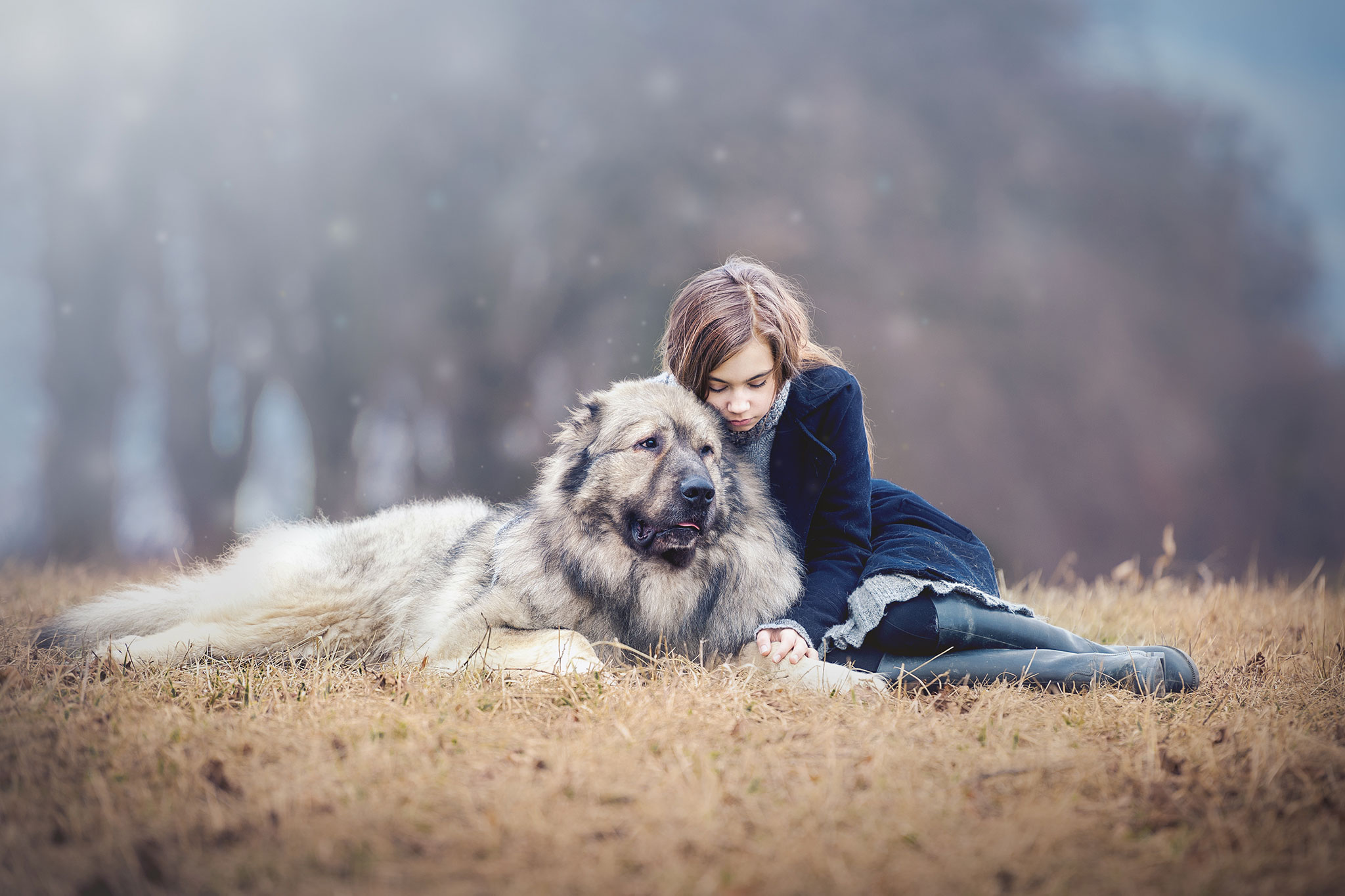 jenta sitter med en stor hund på enga