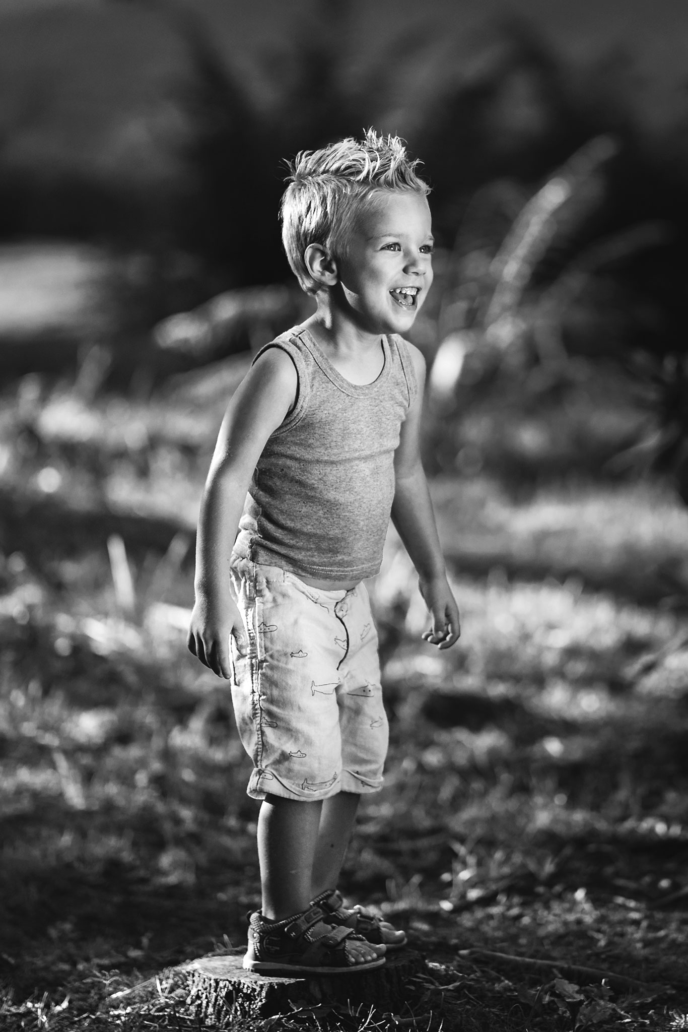 en glad liten gutt løper i skogen