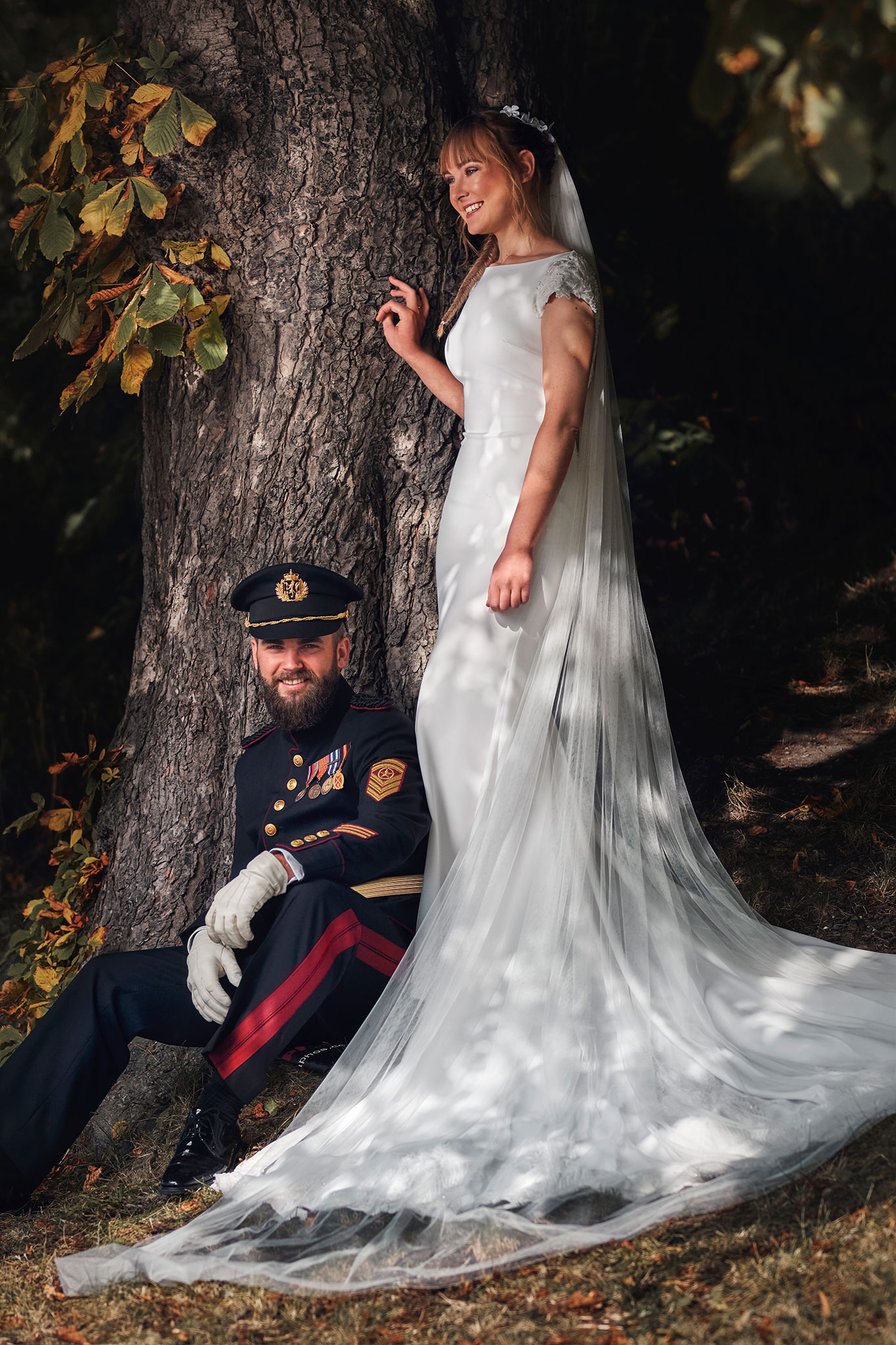 en smilende soldat i gallauniform poserer til bryllupsbilder sammen med bruden