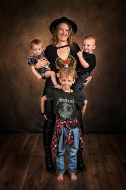 smilende mamma med barn poserer i studio til familiefoto