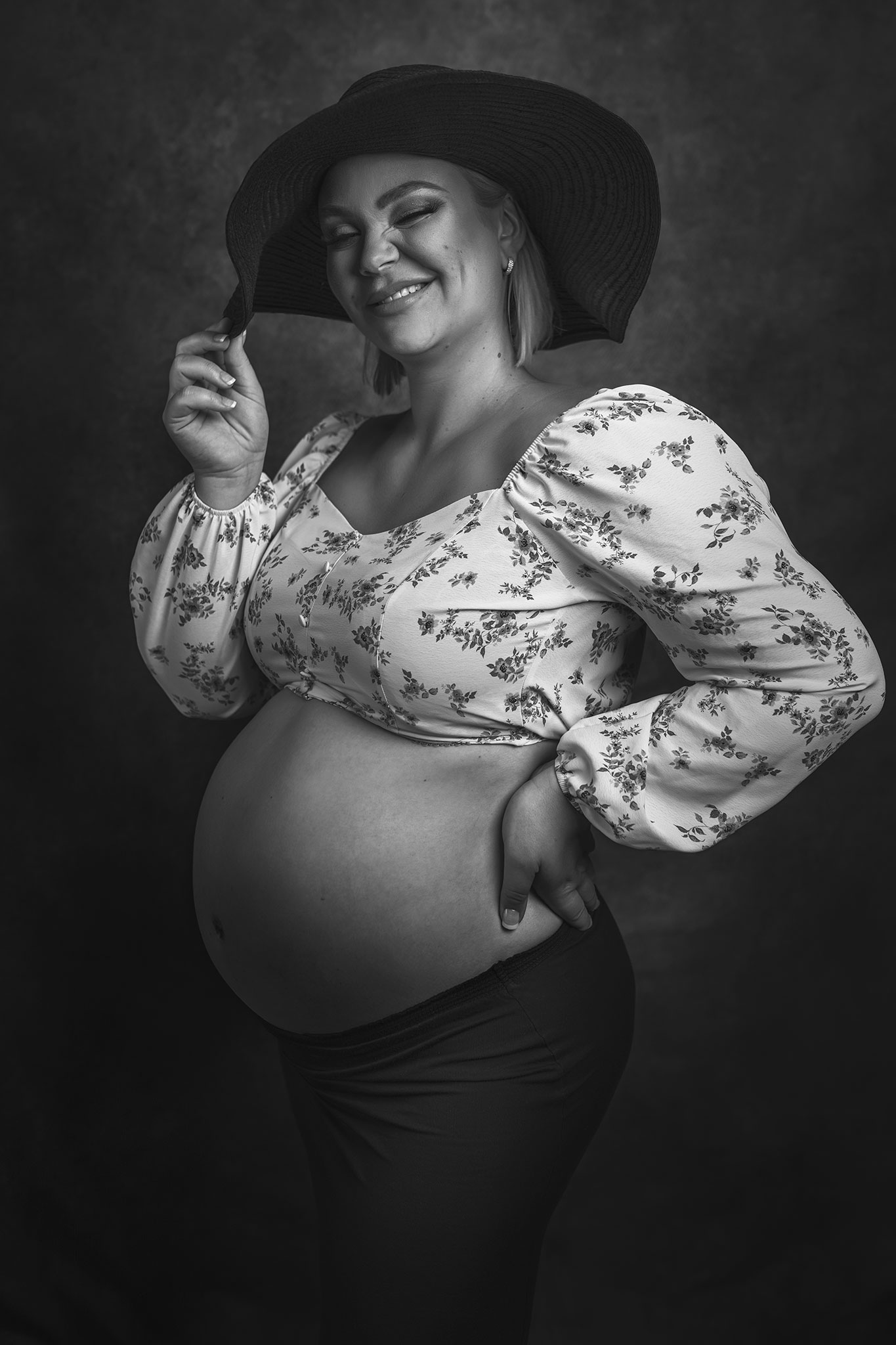 blunkende gravid kvinne med hatt på hodet