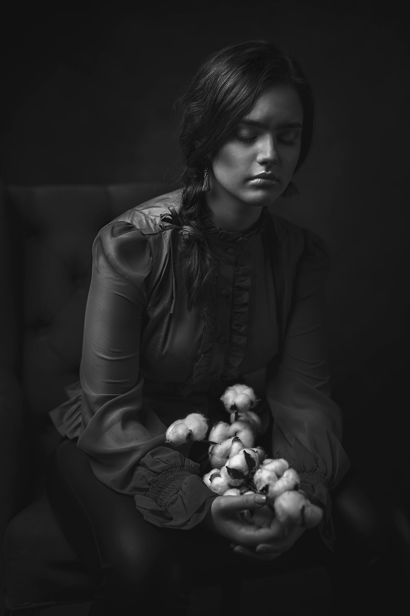 den mørkhårede jenta som holder blomstene sitter på lenestolen med lukkede øyne og drømmer