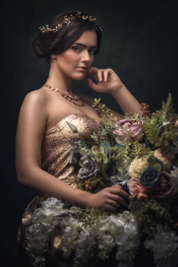 den mørkhårede jenta i en vakker kjole holder blomster
